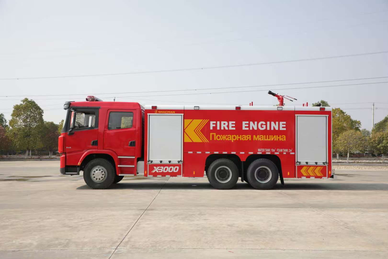 Red SHACMAN X3000 fire truck with equipment compartments and roof monitor