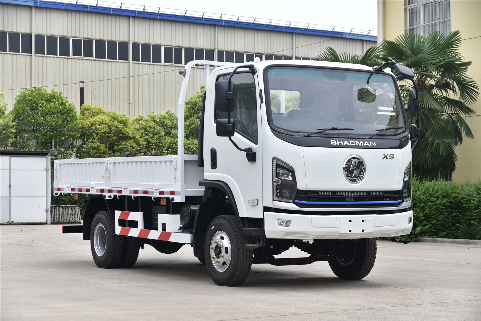White SHACMAN X9 cargo truck with an open side body