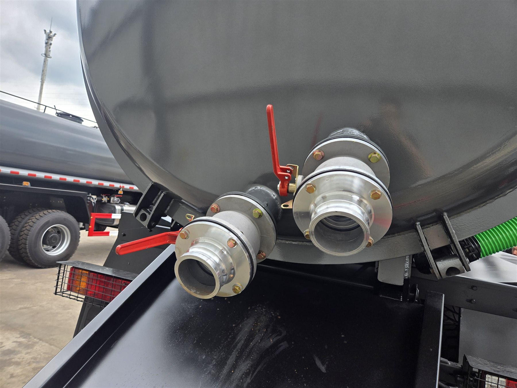 Close-up of rear ball-valve outlets and couplings on the SHACMAN sewage suction tank