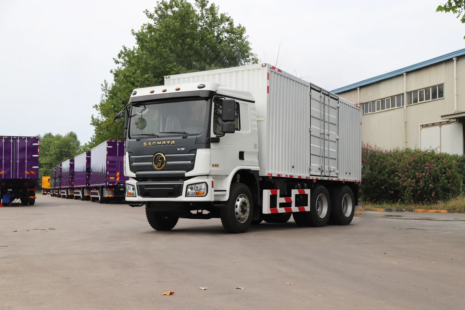 White SAGMOTO X5s 6x4 box cargo truck outside the factory