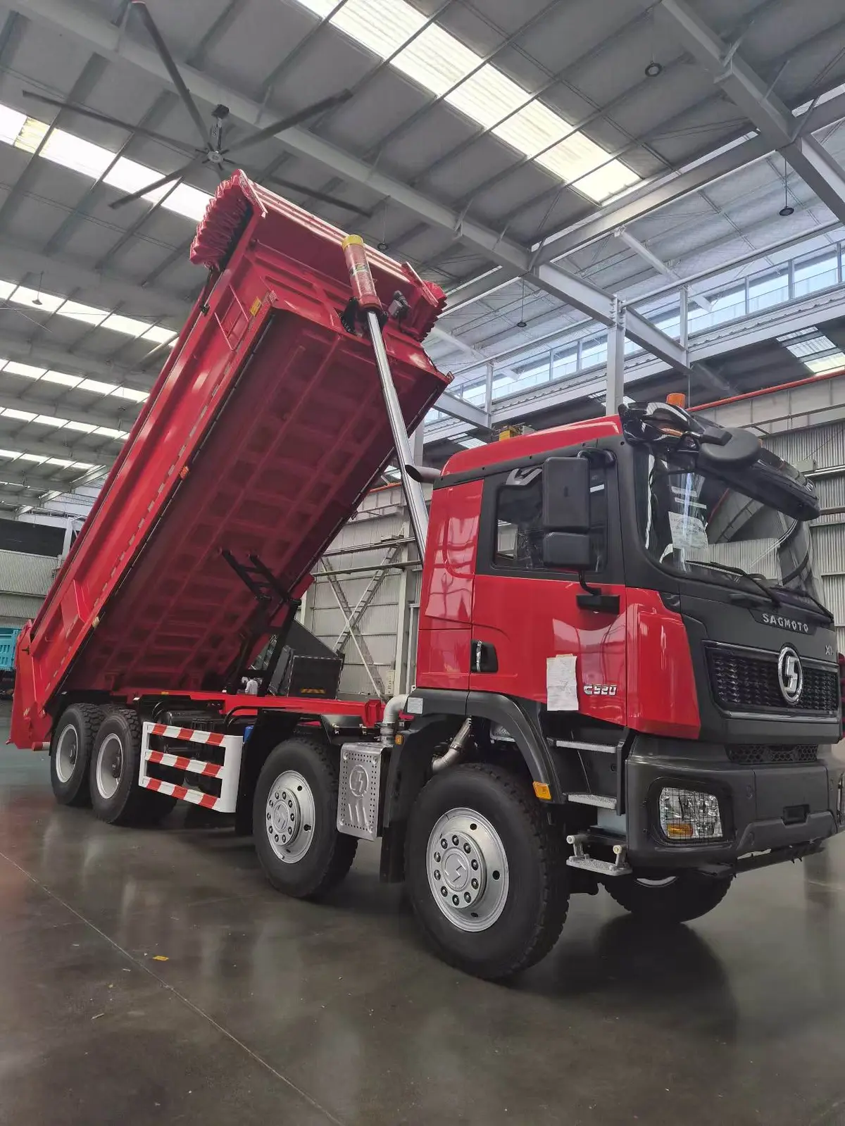 Vista lateral del SAGMOTO X1S 8x4 con cilindro hidráulico y caja elevada